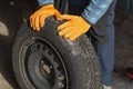 Car mechanik holds winter tire in the garage