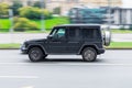 Car Mercedes-Benz G-Class Gelandewagen in motion with blurred background. Mid-size four-wheel drive luxury SUV drive on city