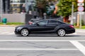 Car Mercedes CLS Class on the road in motion. Fast speed drive on city road. Side view of moving black car on the street Royalty Free Stock Photo