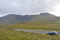 Car in the Middle of a National Road with Vegetation and Mountains in Ireland Royalty Free Stock Photo