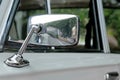 Car mirror in a chrome casing on a gray car