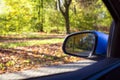 Car mirror Closeup with beautiful autumn landscape in reflection, on the road with the car on empty road blurred background Royalty Free Stock Photo