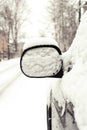 Car mirror covered of snow. Outside