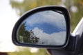 Car mirror on the green background. Blue sky, mirroring, reflection. Sunny day Royalty Free Stock Photo