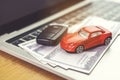 Car model, money and Notebook on wooden desk. shopping online and car payment by using laptop Royalty Free Stock Photo