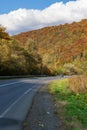 The car moves along a winding asphalt road among the mountains.