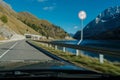 Car moving fast with speed limit violation on a twisty road with a rocky landscape.