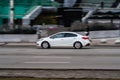 Car moving at high speed on the city street. A white car drives fast through the city with motion blur effect. excess speed limit