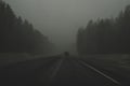 Car moving in snowstorm through the forest. car rides on a winter snowy road in cloudy weather