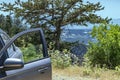 A car with an open door stands on a hill or top of a mountain with view on valley. Summer Landscape Background Royalty Free Stock Photo