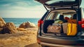 A car with an open trunk with many things and suitcases is standing on the beach by the sea