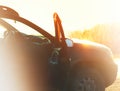 Car with opened door during sunset background