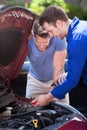 Car Owner With Mechanic Testing Car Battery Royalty Free Stock Photo