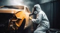 Car painter in protective clothes and mask painting a car, mechanic using a paint spray gun in a painting chamber. Bodywork, Royalty Free Stock Photo