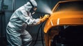 Car painter in protective clothes and mask painting a car, mechanic using a paint spray gun in a painting chamber. Paint job, car Royalty Free Stock Photo