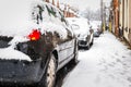 Car parked on british street under winter snow fall in england uk