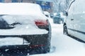 Car parked on city street covered with thick snow layer during snowstorm blizzard at winter. Vehicle tail at cold winter Royalty Free Stock Photo