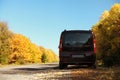 Car parked on country road near autumn fores Royalty Free Stock Photo