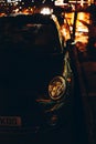 a car parked at the curb on a rainy night with headlights shining brightly Royalty Free Stock Photo