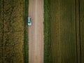 Car parked on dirt road with crop fields surrounded