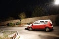 Car parked on driveway at night covered in snow. Winter scene Royalty Free Stock Photo