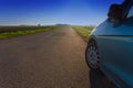 Car parked at the edge of an empty country road Royalty Free Stock Photo