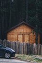Car parked in front of the forest cottage home in pine woodland at night