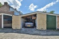 a car parked in a garage with doors open