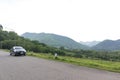 The car is parked on a high road. With mountains and sky in the background Royalty Free Stock Photo