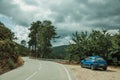 Car parked next to road on a hilly landscape