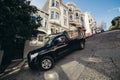 Car parked safely with turned wheels on slanted street in San Francisco.