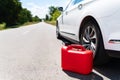 A car parked on the side of the road, an empty red canister. The driver is on the road. Help on the road. Fuel shortage - oil, Royalty Free Stock Photo