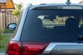 Car parked on the street in residential district, back view. Mock up of rear window for sticker or decals Royalty Free Stock Photo