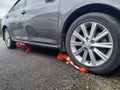 the car is parked with wheels on the barrier cones.