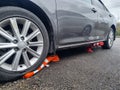 the car is parked with wheels on the barrier cones.