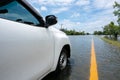 Car parking on a Huge flood highway. white car driving on a flooded road with yellow Road line