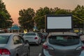 Car parking with summer cinema, green trees, cars on summer even