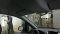 Car passing through the car wash, a person washes the car with a non-contact sink, a view from inside the car