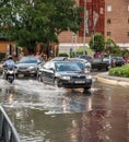 Car passing through a roundabout flooded by a strong summer storm