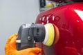 Car polish wax worker hands applying protective tape before polishing. Buffing and polishing car. Car detailing. Man holds a polis Royalty Free Stock Photo