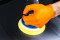 Car polish wax worker hands applying protective tape before polishing. Buffing and polishing car. Car detailing. Man holds a polis Royalty Free Stock Photo