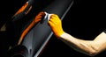 Car polish wax worker hands polishing car. Buffing and polishing vehicle with ceramic. Car detailing. Man holds a polisher in the Royalty Free Stock Photo