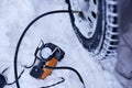 car pump compressor pumps up a flat tire of a car in winter on a snowy path in the forest close-up. Broken cars concept