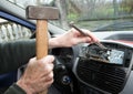 Car radio removal, replacement - amateur at work with hammer and Royalty Free Stock Photo