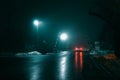 Car at a railway crossing at night during fog, winter