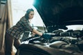 Car reapir, exam. Young pretty girl, auto mechanic working at auto service station using different work tools. Gender Royalty Free Stock Photo