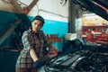 Car reapir, exam. Young pretty girl, auto mechanic working at auto service station using different work tools. Gender Royalty Free Stock Photo