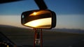 Car rear view mirror. Displays orange dawn. Visible road, hills and steppe. Royalty Free Stock Photo