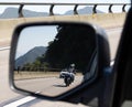 Car rear view mirror with the image of a biker approaching to overtake