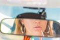 Car rearview mirror girl applies lipstick